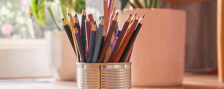 A tin can with colored pencils